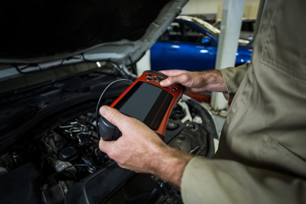 Technician using an OBD-II diagnostic scan tool on a vehicle